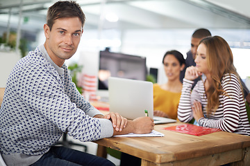 Image showing Man, portrait and smile at desk with meeting for business or creative company, planning and teamwork. Male person or designer, office and collaboration for startup agency, paperwork and documents.
