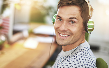 Image showing Portrait, office and headphone for happy male worker, music or podcast for entertainment. Smile, employee and listening or working at workspace in Holland, startup or entrepreneur for tech company