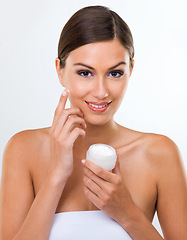 Image showing Skincare, cream and dermatology for woman in studio with product for moisture, smooth and clean on face. Young person and smile with finger on cheek with lotion for beauty, soft and wellness