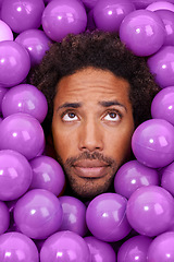 Image showing Ball pit, thinking and face of black man with plastic toys for wondering, question and thoughtful on background. Confused, facial expression and person with purple balls, decoration and objects