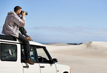 Image showing Road Trip, dunes and man in nature for photography, desert landscape and travel for holiday. Pictures, 4x4 and nomad male person in Sahara terrain, outdoor and transport in dry climate and scenery