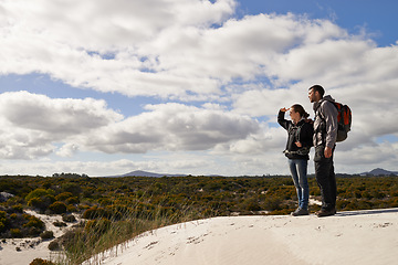 Image showing Sand dunes, nature and couple hiking for adventure, desert and travel on outdoor holiday for love or view. Hill, explorers walking and nomad people in Sahara terrain experience, trip or dry climate