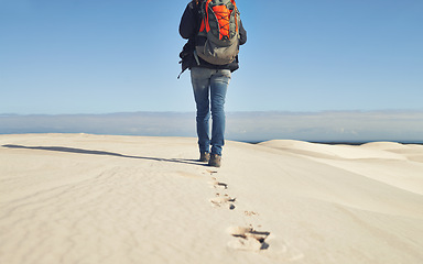 Image showing Walking, sand dunes or legs of person for adventure, desert landscape and travel for holiday vacation trip. Back view, hiker and nomad explorer hiking in Sahara terrain, outdoor and dry climate