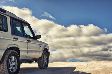 Image showing Dunes, vehicle and sky with clouds, adventure and transport on road trip for holiday. Outdoor, sand and 4x4 for travel in Dubai for desert landscape, nature and truck in sunshine and wilderness