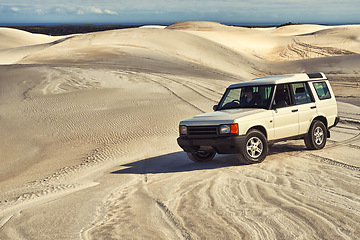 Image showing Car, desert and driving with travel and transportation outdoor, off road vehicle for sand dunes and journey on vacation. Van, 4x4 or SUV with adventure, explore destination and tourism in Dubai