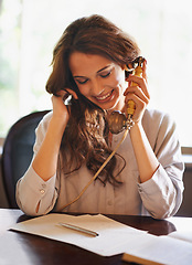 Image showing Businesswoman, smile and phone call conversation, landline and notes on paper. Happy, vintage telephone and communication for professional antiques dealer, contact and talking at desk in office