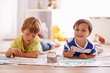 Image showing Children, painting and creative with paint brush on floor or playroom, hobby and drawing together at home. Young boys, motor skills and growth for childhood development with smile for artwork