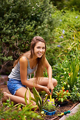 Image showing Woman, tool and flowers for gardening and plant in environment outdoor with soil and sunshine. Gardener and smile with spade on grass for sustainability, growth and earth for lawn or garden and eco