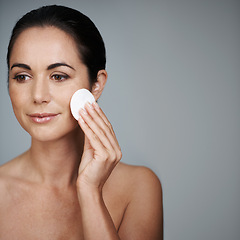 Image showing Mature woman, pad and hygiene in studio, skin care and facial treatment on gray background. Female person, cotton and swab for grooming in daily routine, mockup space and dermatology to remove makeup