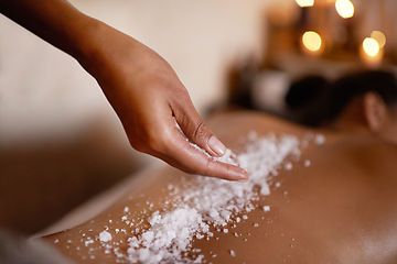 Image showing Hand, massage and salt with woman at spa on bed or table for luxury pamper treatment closeup. Relax, wellness and back of customer at beauty resort or salon for holistic therapy or exfoliation