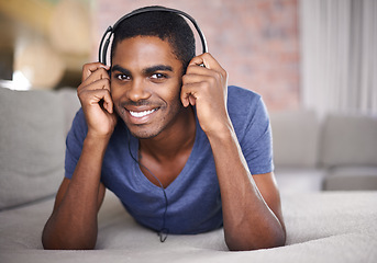 Image showing Man, portrait and happy with music on sofa for audio streaming, podcast or headset in living room of home. Student, black person or face with headphones for relax, radio subscription or rest on couch