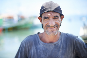 Image showing Fisherman, portrait and rugged man with smile, harbour and wrinkles from sunlight exposure. Boats, ships and water or fishing for work in Brazil, closeup and senior male angler for career by ocean