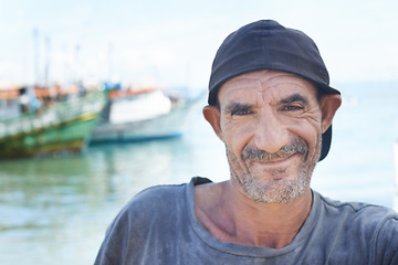 Image showing Fisherman, portrait and rugged man with smile, boats and fishing trawler in ocean. Wrinkles, aged and mature happy male from Brazil, close up and self employed with nomadic lifestyle on the water