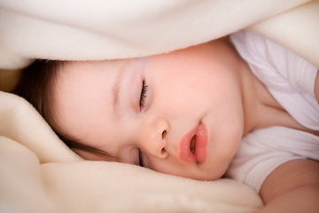 Image showing Baby, sleeping and home with relax, nap and nursery with peace in a bed with blanket. Morning, youth and kid with dream of an infant with child development from rest in a bedroom with a newborn