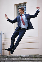 Image showing Business, jump and excited man with phone in city street celebration for wow, news or winner fist gesture. Smartphone, energy or male entrepreneur with app alert for online competition prize or lotto