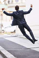 Image showing Business, excited and man jump with phone in city street celebration for wow, news or winner fist gesture. Smartphone, energy or entrepreneur back with app alert for online competition prize or lotto