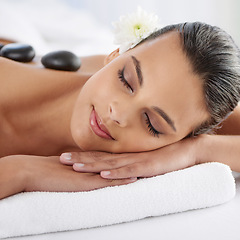 Image showing Zen, hot stone and woman with massage at spa for wellness, health and back treatment. Self care, cosmetic and young female person sleeping for warm rock skin therapy at natural beauty salon.
