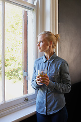 Image showing Woman, tea and thinking at window in home for herbal detox or healthy drink with leaves, relax or morning. Female person, glass and thoughts for wellness benefits or apartment, beverage or breakfast