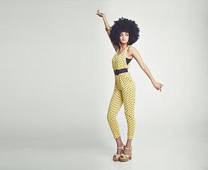 Image showing Black woman, jumpsuit and fashion dancing in studio for vintage look, gen x and retro style for old school. African girl, afro and unique with white background for pose, isolated and confident.