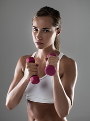 Image showing Serious woman, portrait and workout with dumbbells for fitness, weightlifting or exercise on a gray studio background. Female person, bodybuilder or athlete with small barbells for training on mockup