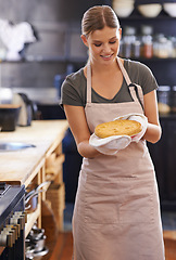 Image showing Happy, woman and pie in kitchen at bakery with chef in restaurant cooking a lunch. Person, smile and baker with food in hands or pride and confidence in skill of baking pastry dish for dinner