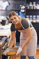 Image showing Bakery, oven and woman in kitchen with a pie in portrait cooking as chef at restaurant or hotel. Person, smile and baker with food in catering business and baking dinner or lunch dish with skill