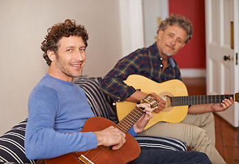 Image showing Happy man, portrait and relax with family, guitar or music for acoustic sound or instruments at home. Young man playing or strumming with smile and father for classical audio on living room sofa