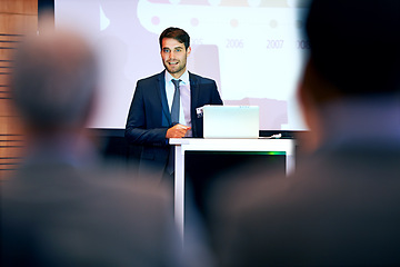 Image showing Business man, podium and presentation with projector screen, conference or workshop with laptop for slideshow. Corporate training, seminar and speaker with info, audience and professional speech