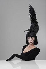 Image showing Woman, portrait and feather for fashion in studio for fantasy or magic with unique creativity for art or illusion. Female person, isolated and white background for designer clothes, diva and surreal.