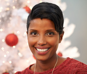 Image showing Smile, christmas and portrait of woman at her home for festive event, party or celebration. Happy, holidays and face of female person from Colombia with xmas tree on sofa in living room at apartment.