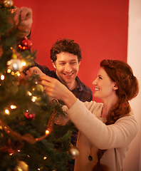 Image showing Couple, tree and christmas with smile, decoration and celebration for holiday spirit. Man, woman and love with happy marriage, relationship and romance with ornament for vacation break and care