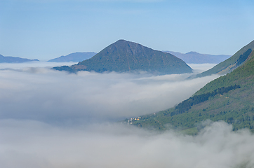 Image showing Majestic peak emerging above sea of morning mist in tranquil mou