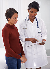 Image showing Tablet, healthcare and patient with doctor in hospital for consultation on diagnosis or treatment. Discussion, research and woman with female medical worker reading on digital technology in clinic.