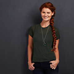 Image showing Portrait, ginger and happy woman in studio for fashion isolated on dark background mockup space. Confidence, smile and person with red hair in casual clothes, tshirt or stylish on backdrop in Ireland