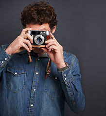 Image showing Vintage, fashion or photography by man, camera lens or capture of creative, graphic or style. Male photographer, film or retro gadget as trendy, denim or urban outfit in studio on grey background