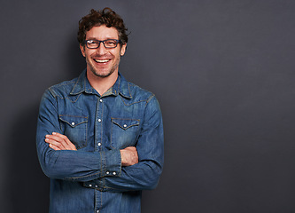 Image showing Studio, portrait and man with smile, glasses and casual fashion on mockup space for creative professional. Relax, happy and person with confidence, pride and trendy denim style on dark background