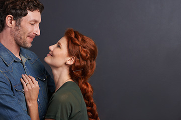 Image showing Love, smile and happy couple in studio mockup together with relationship trust, care and support. Romance, man and woman embrace on dark background with commitment, loyalty and affection in marriage