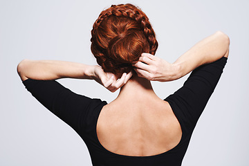 Image showing Back of woman, hair and braid hairstyle for beauty, elegant redhead with glamour and cosmetology on white background. Haircare, luxury or regal, hands fixing plait or twist for cosmetic care