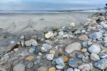 Image showing Serene beachscape with pebbled shoreline and gentle waves at twi