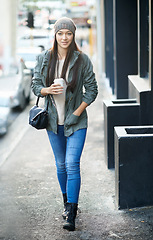 Image showing Women, travel and portrait on sidewalk in city for tour on urban culture or cityscape, vacation and journey in town. Female person, smile and walk with coffee, explore and holiday or trip in New York