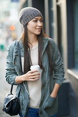 Image showing Woman, fashion and denim with coffee, travel and city street or background for style. Asian student, beanie and jacket in cape town with winter, cold and adventure with urban holiday for confidence