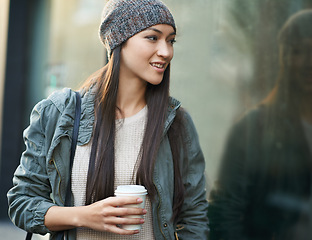 Image showing Woman, fashion and window with city, coffee and urban street or background for style. Female student, beanie and jacket in cape town with winter, cold and travel with morning commute for confidence
