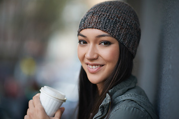 Image showing Portrait, city and smile with woman, coffee and relaxing with winter season and wool cap. Face, person and girl with tea and cappuccino with urban town and knitted beanie with happiness in a street