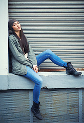 Image showing Woman, fashion and jeans with portrait, urban and city street or background for style. Female student, beanie and jacket in cape town with winter, cold and lazy with metal garage door for confidence