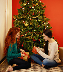 Image showing Christmas, happy and women with presents, tree with decor in living room for holiday. Gift giving, smile and family sitting on floor together, Christian celebration on Xmas eve with mother and child