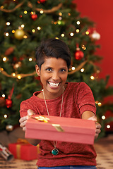 Image showing Christmas, portrait and woman with gift giving for celebration offer and kindness on festive holiday. Smile. person and face with happiness for present, share and special event in living room