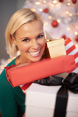 Image showing Woman, portrait and Christmas gifts at tree for holiday giving for festive season celebration, event or packaging. Female person, face and excited or vacation break with present, giveaway or prize