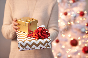 Image showing Hands, gift box and Christmas holiday at tree for festive season or parcel packaging, celebration or giveaway. Person, present and giving for surprise deal for winter vacation event, party or decor