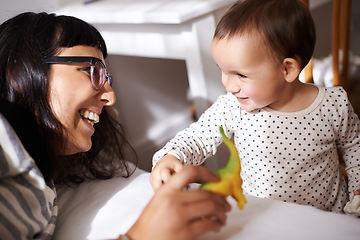 Image showing Mother, love and kid with toy in bedroom, play and happy for childhood in home on bed. Mommy, daughter and security in connection or trust, child development and relax on weekend for bonding