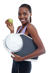 Image showing Portrait, apple and scale with exercise black woman in studio isolated on white background for weight loss. Fitness, smile and diet with confident young sports model training for health or nutrition